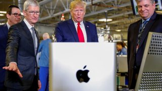Apple CEO Tim Cook, left center, escorts President Donald Trump as he tours Apple’s Mac Pro manufacturing plant in Austin, Texas, Nov. 20, 2019.