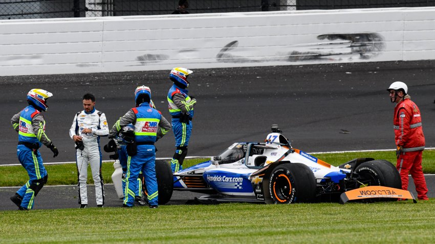 Kyle Larson, second from left, is checked after he hit the wall
