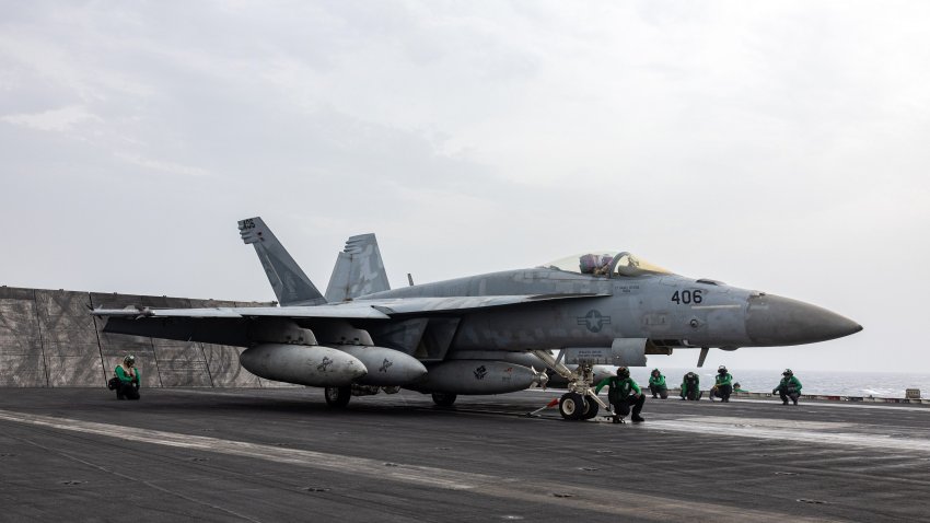 Flight deck crew members prepare to catapult an F/A-18 Super Hornet fighter jet aboard the USS Dwight D. Eisenhower (CVN 69) aircraft carrier in March 2024.