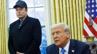 Elon Musk stands behind Donald Trump in the Oval Office