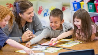 Teacher helping students with project in classroom