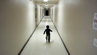 FILE - An asylum-seeking boy from Central America runs down a hallway after arriving from an immigration detention center to a shelter in San Diego, Dec. 11, 2018.