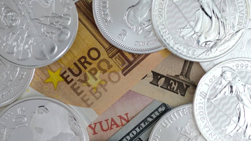 In this photo illustration, banknotes of Euro, Japanese Yen, Chinese Yuan and US dollar bill are placed under one-ounce silver bullion coins arranged on February 20, 2021 in Katwijk, Netherlands.