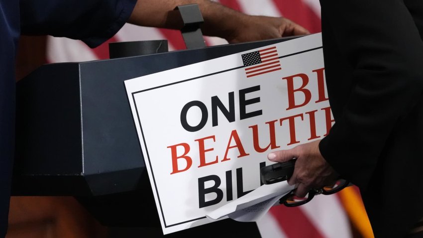 Staff members remove a sign following a press conference after the House passage of the tax and spending bill, at the U.S. Capitol on May 22, 2025 in Washington, DC.