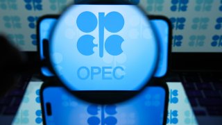 The OPEC logo is displayed on a mobile phone screen in front of a computer screen displaying OPEC icons in Ankara, Turkey, on June 25, 2024.