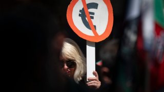 A woman holds a placard with the symbol of Euro during a demonstration against Bulgaria entering the Eurozone in Sofia on June 4, 2025.