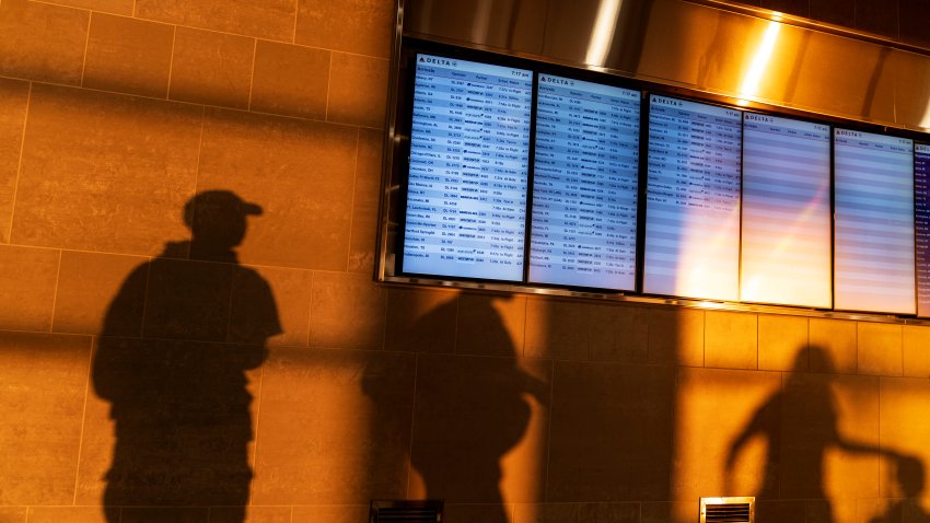 FILE – The sunrise casts shadows of travelers moving past gate information screens at Detroit Metropolitan Airport on Labor Day, Monday, Sept. 4, 2023, in Detroit.