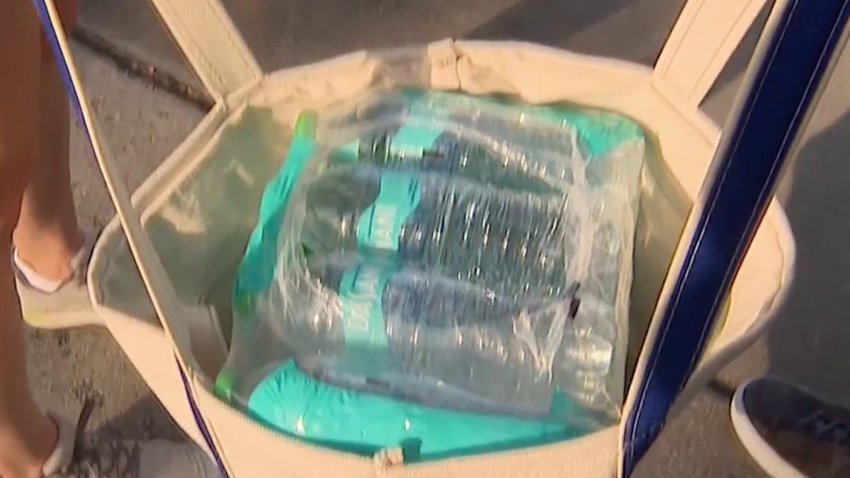 Northwest D.C. residents carry a bag full of bottled water home during a boil water advisory.