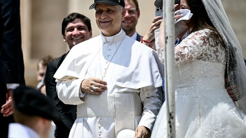 Pope Leo XIV (C) reacts wearing a Chicago White Sox baseball team cap as he meets newly wedded couples during the weekly general audience in St Peter’s Square at the Vatican on June 11, 2025. (Photo by Filippo MONTEFORTE / AFP) (Photo by FILIPPO MONTEFORTE/AFP via Getty Images)