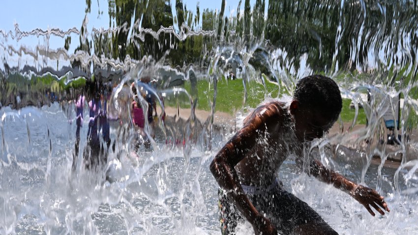 TOPSHOT – People cool off in the splash pool at Yards Park in Washington, DC, on June 20, 2025. The United States is experiencing its first significant heat wave of the year, beginning June 20 across the Great Plains and expanding into parts of the Midwest and Great Lakes over the weekend, according to the National Weather Service (NWS). (Photo by Alex WROBLEWSKI / AFP) (Photo by ALEX WROBLEWSKI/AFP via Getty Images)