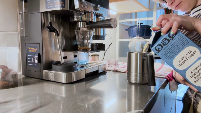 Child pours milk into frother for espresso machine