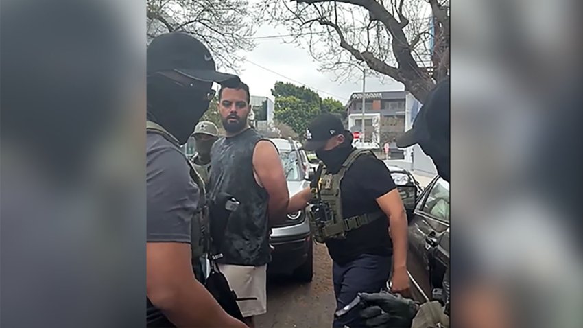 A man is detained by ICE agents in Los Angeles, on Tuesday.