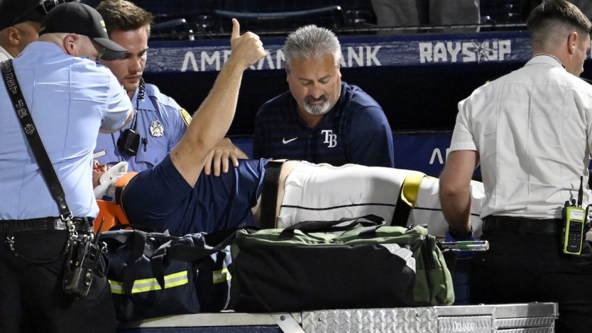 Tampa Bay Rays’ Hunter Bigge gives a thumbs up as paramedics tend to him after being hit by a foul ball while in the dugout during the seventh inning of a baseball game against the Baltimore Orioles, Thursday, June 19, 2025, in Tampa, Fla. (AP Photo/Jason Behnken)