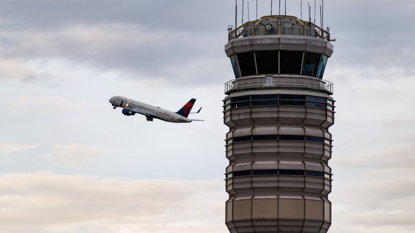 A Delta Airlines plane takes off near the air traffic control tower at Ronald Reagan Washington National Airport (DCA) in Arlington, Virginia, US, on Tuesday, Oct. 28, 2025. Transportation Secretary Sean Duffy warned that flight delays could get worse as the US government shutdown enters its 28th day and air traffic controllers miss their first full paycheck. Photographer: Samuel Corum/Bloomberg via Getty Images