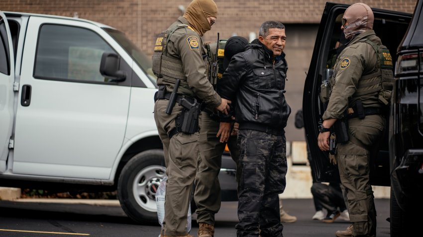 Immigration and Customs Enforcement agents take people they detained earlier to a parking lot before transferring them to an ICE facility in Chicago on Oct. 31.