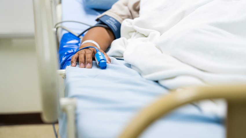 In the Hospital Sick Male Patient Sleeps on the Bed. Heart Rate Monitor Equipment is on His Finger.