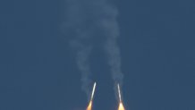 Two solid rocket boosters separate and fall toward Earth.