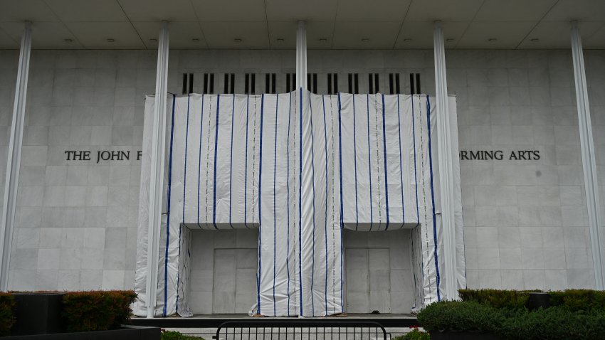 A tarp covers the facade of the John F. Kennedy Memorial Center for the Performing Arts in Washington, DC, on June 14, 2026. Workers began removing President Donald Trump’s name from the facade of the John F. Kennedy Center for the Performing Arts on June 13, after a federal judge ruled that its renaming was unlawful. The effort came after a judge rejected a last-minute bid by the center’s board to halt the removal of Trump’s name. (Photo by Alex WROBLEWSKI / AFP via Getty Images)