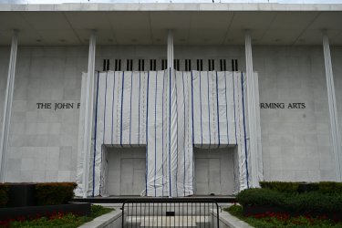 A tarp covers the facade of the John F. Kennedy Memorial Center for the Performing Arts in Washington, DC, on June 14, 2026. Workers began removing President Donald Trump's name from the facade of the John F. Kennedy Center for the Performing Arts on June 13, after a federal judge ruled that its renaming was unlawful. The effort came after a judge rejected a last-minute bid by the center's board to halt the removal of Trump's name. (Photo by Alex WROBLEWSKI / AFP via Getty Images)