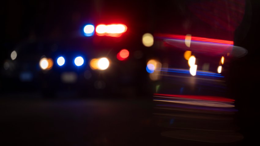 Abstracted view of police lights on a city street at night with lens flare.