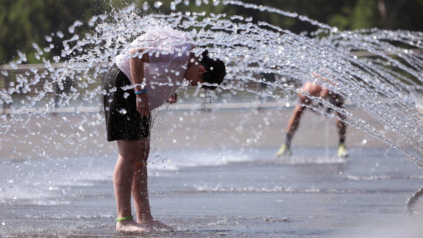 People cool off in a fountain at the Georgetown Waterfront Park on July 02, 2026 in Washington, DC. Temperatures in the nation’s capital are expected to top 100 degrees as a heat wave stretching from the Midwest to the East Coast impacts up to 90 million Americans. (Photo by Kevin Dietsch/Getty Images)