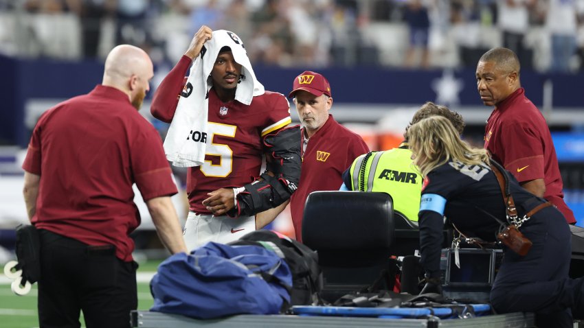 ARLINGTON, TEXAS – SEPTEMBER 20: Jayden Daniels #5 of the Washington Commanders looks on before being carted off the field after sustaining an injury against the Dallas Cowboys in the second quarter of a game at AT&T Stadium on September 20, 2026 in Arlington, Texas. (Photo by Stacy Revere/Getty Images)