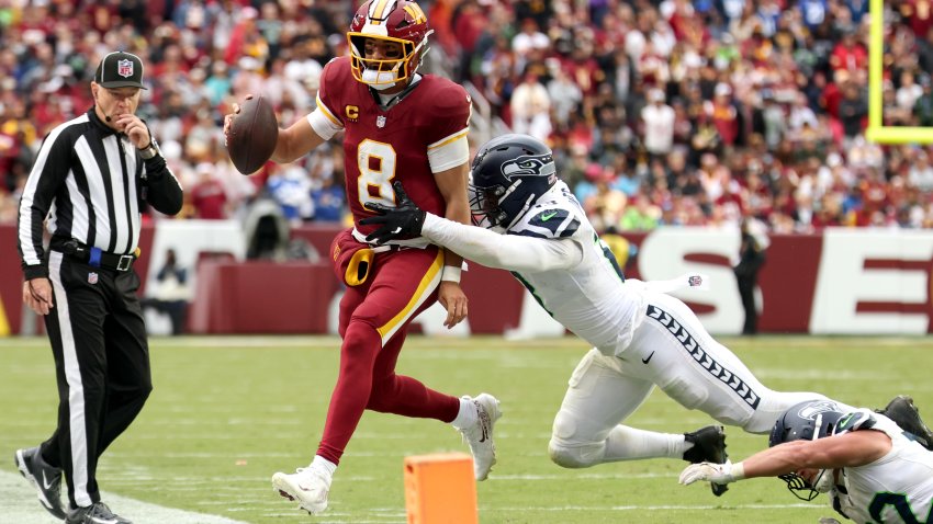 LANDOVER, MARYLAND – SEPTEMBER 27: Marcus Mariota #8 of the Washington Commanders scrambles against Ernest Jones #13 of the Seattle Seahawks during the fourth quarter at Northwest Stadium on September 27, 2026 in Landover, Maryland. (Photo by Scott Taetsch/Getty Images)