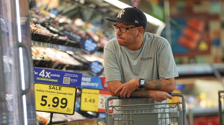 A shopper looks at the meat section of a grocery store