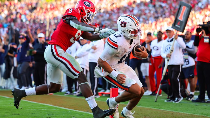 Auburn quarterback Byrum Brown, right, scores a touchdown ahead of Georgia linebacker Chris Cole, left, during the second half of an NCAA college football game, Saturday, Oct. 17, 2026, in Athens, Ga.