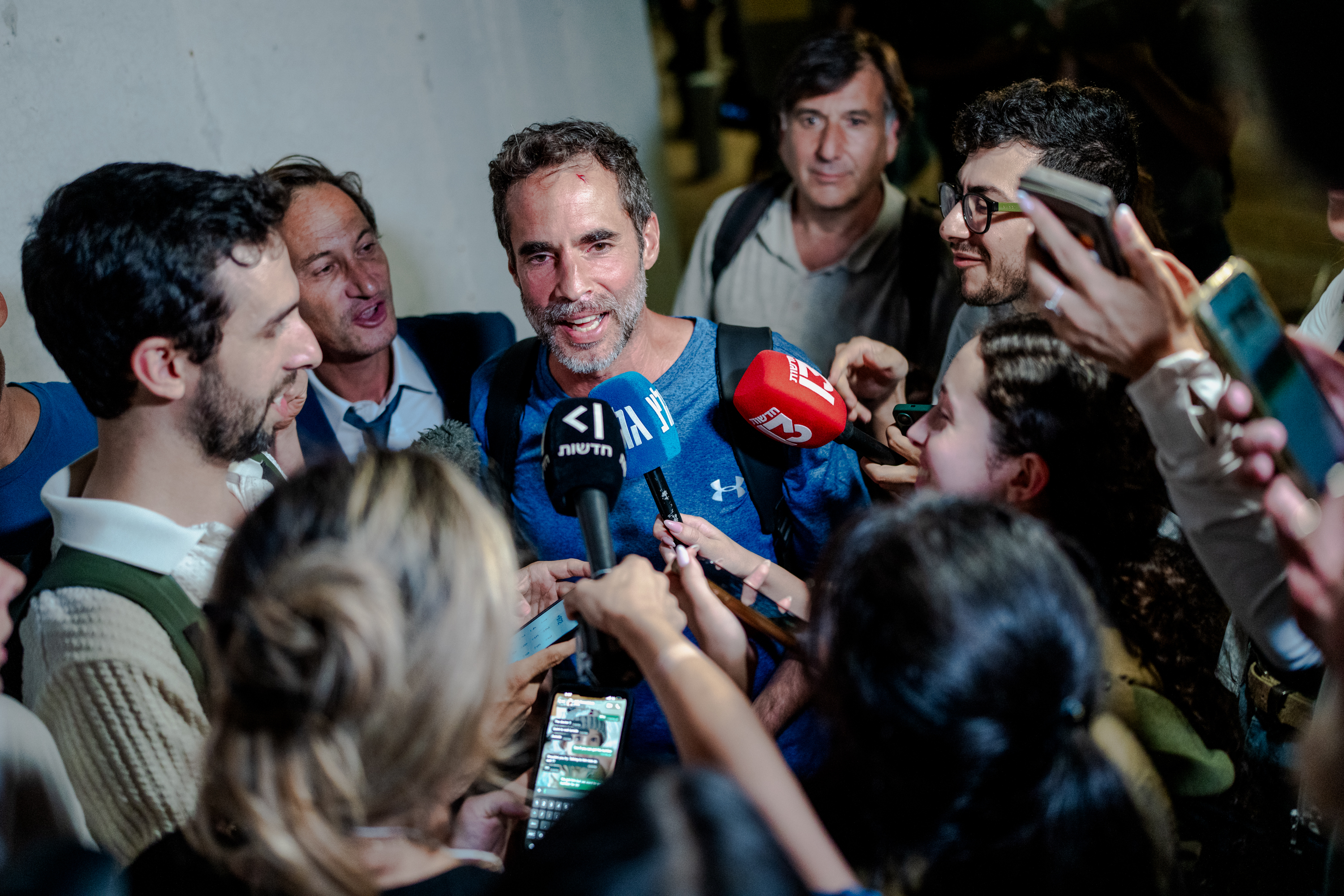 Assaf Regavim, who filmed the first widely circulated video from inside the cabin and helped overpower the pilot, talks to reporters surrounded by news mics and phones at Ben Gurion Airport on Sept. 30, 2026, in Tzafria, Israel.